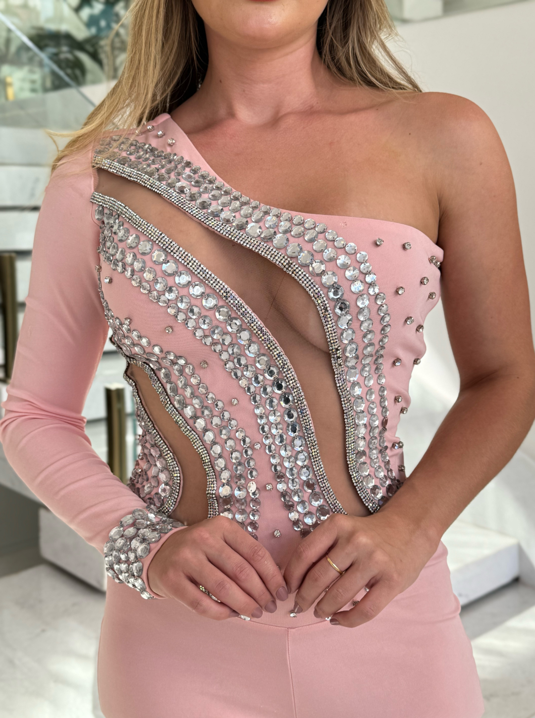 Macacão rosa WLC Catarina com pedrarias, detalhes elegantes, tecido leve e modelo moderno, usado por uma mulher com cabelo castanho claro.